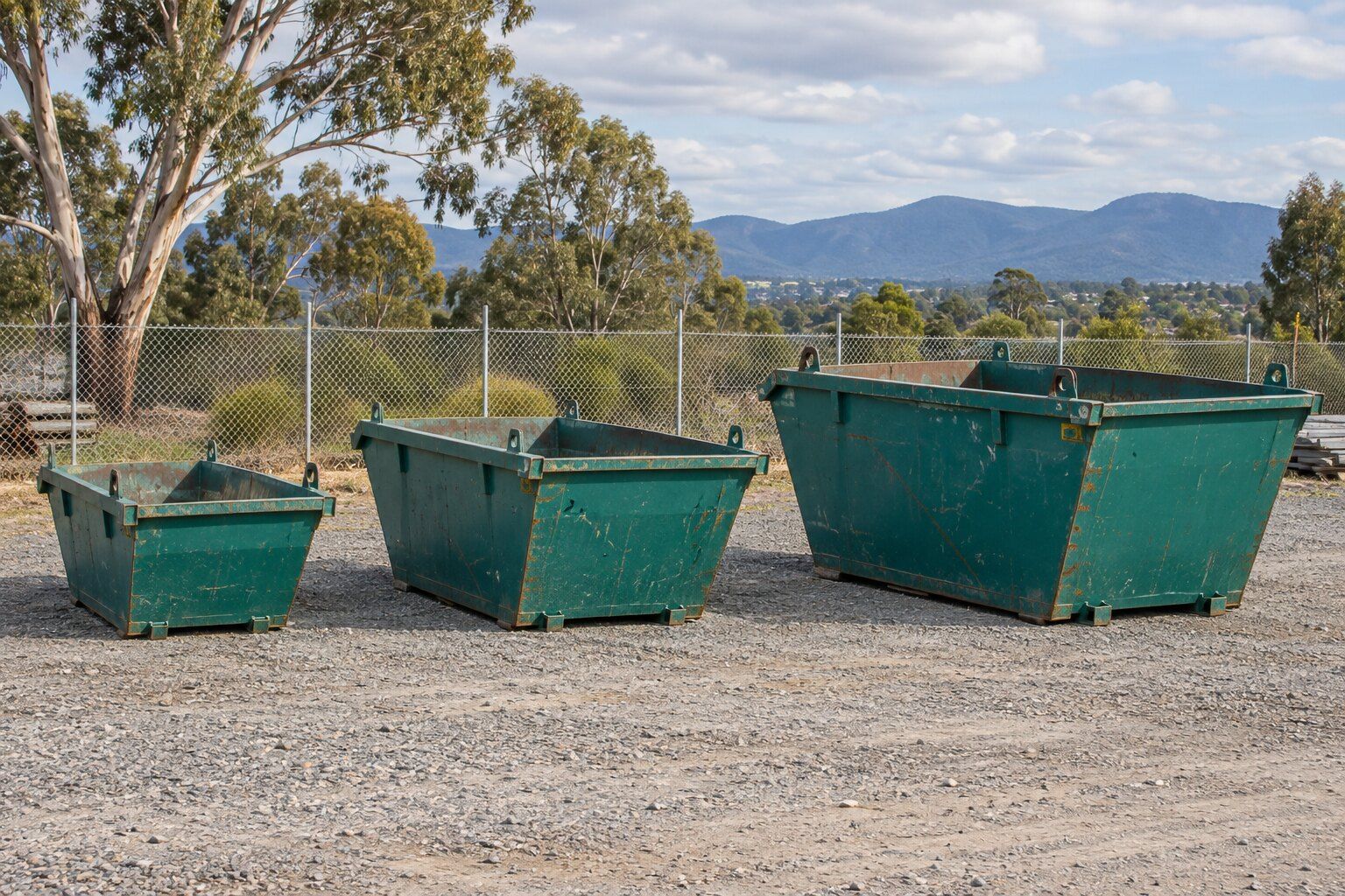 Skip bin sizes, Melbourne: a 2 m³ mini skip, a 4 m³ skip and an 8 m³ skip side by side in a depot yard